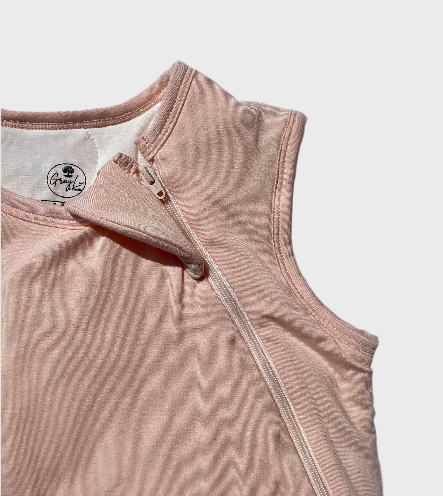 Pink sleep sack baby outfit with zipper on a light gray background