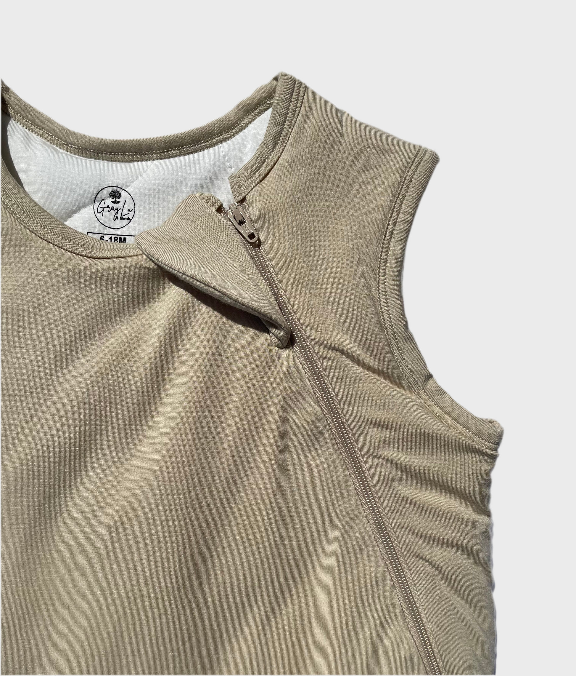 Beige sleep sack with two way zipper on a light gray background